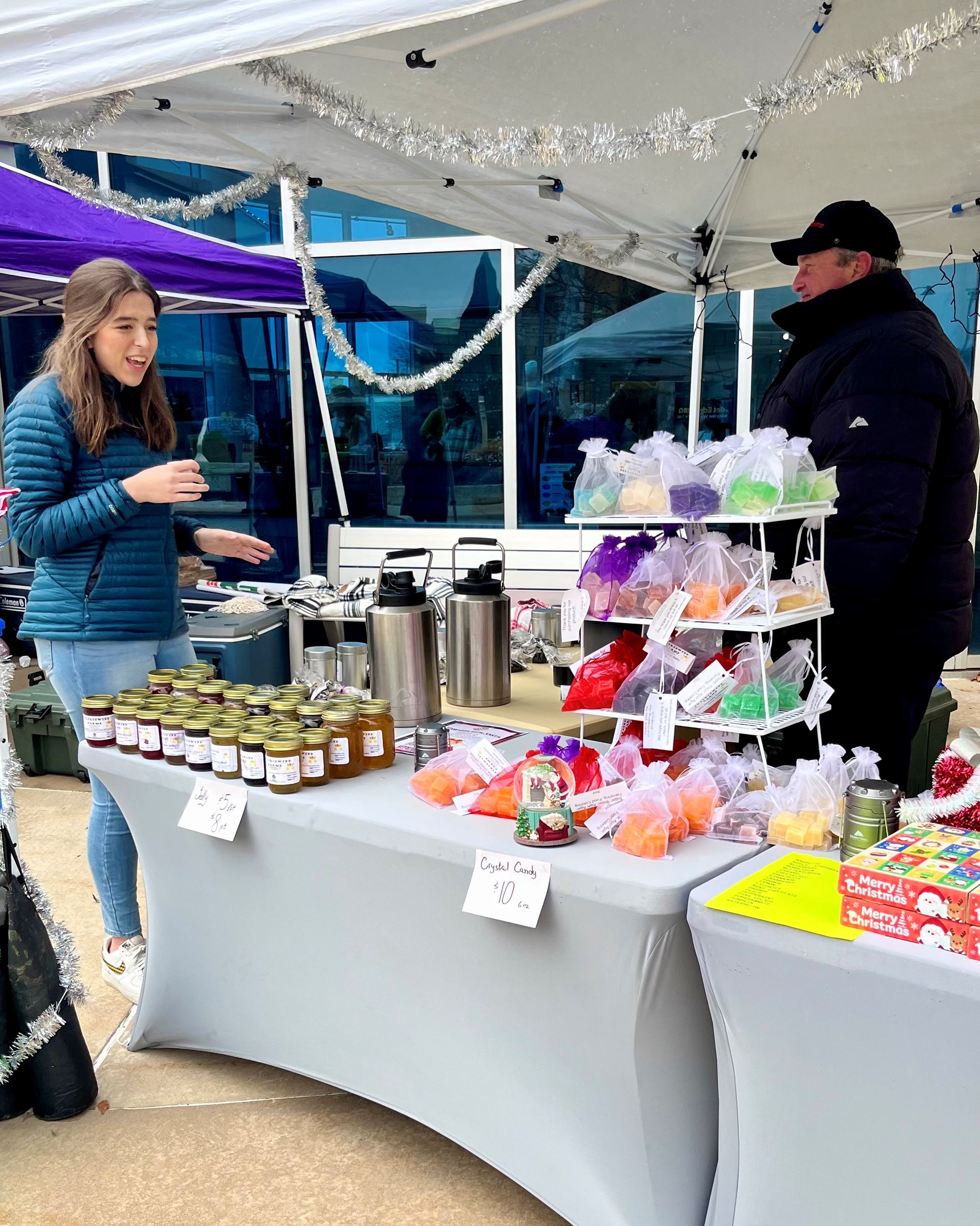 man and woman talking at booth outside